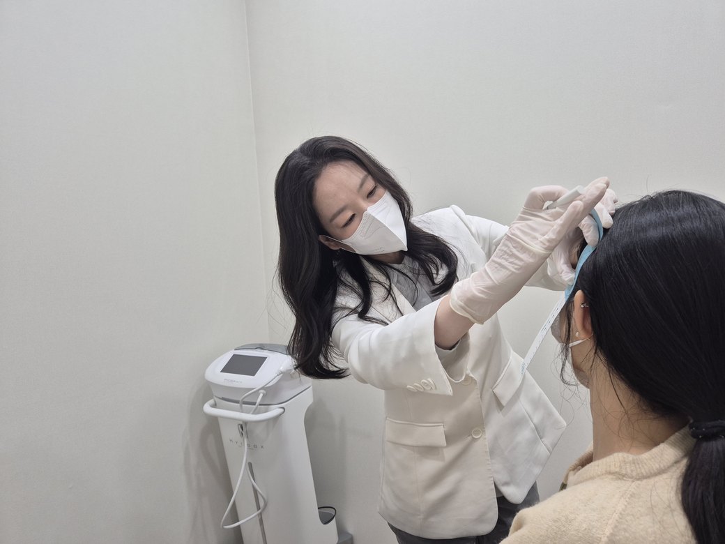 시술실에서 장갑을 끼고 환자 얼굴에 시술하는 최진숙 대표원장