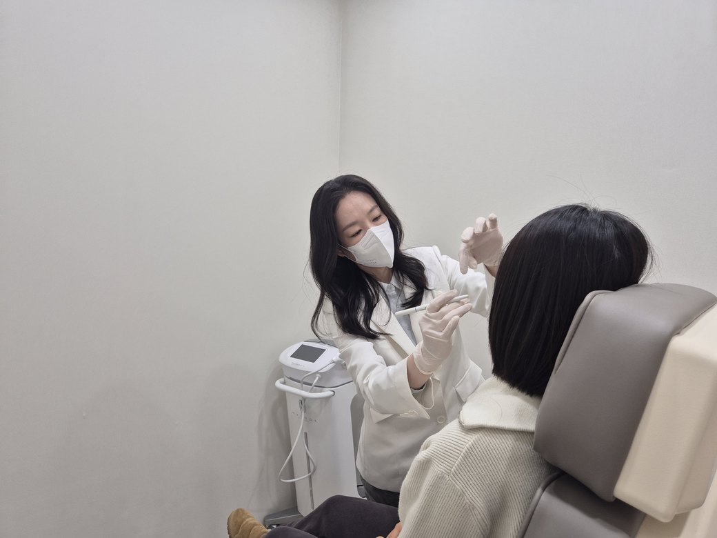 시술실에서 환자 얼굴을 살피며 시술하는 최진숙 원장
