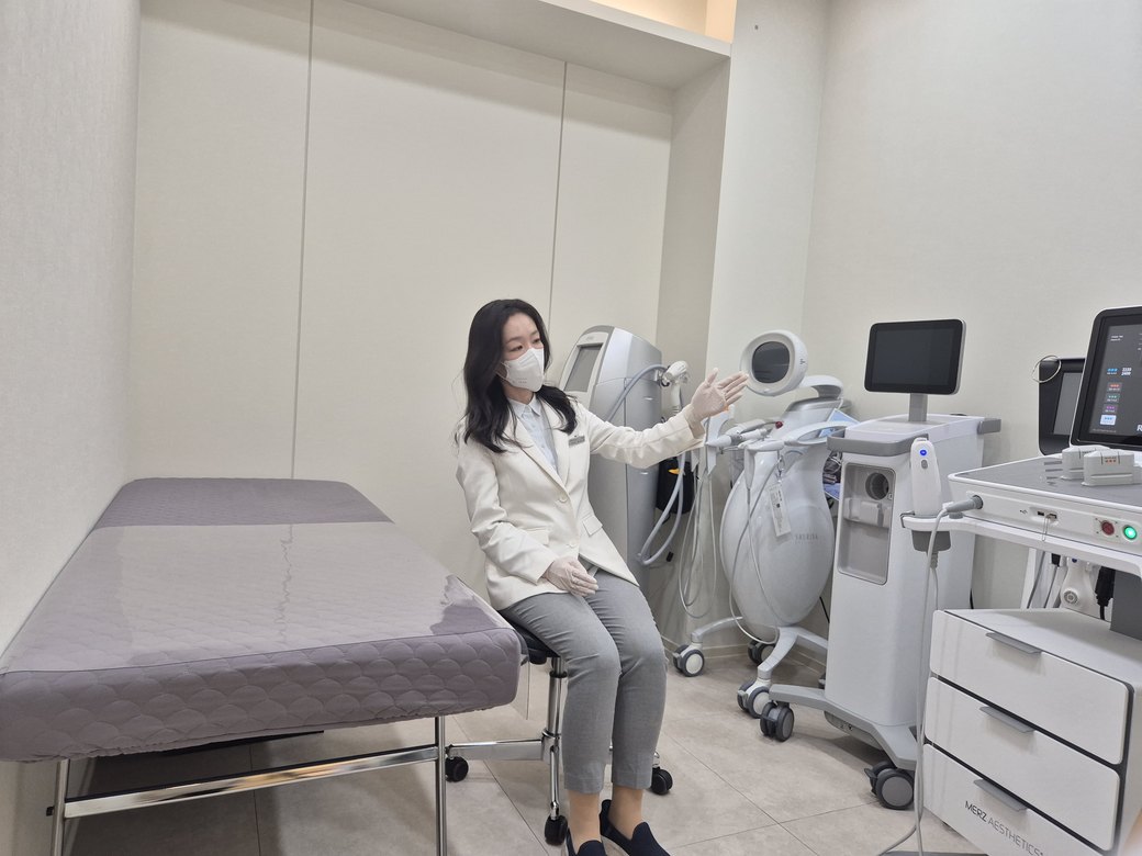 시술실 장비 옆에 앉아 설명하는 최진숙 원장