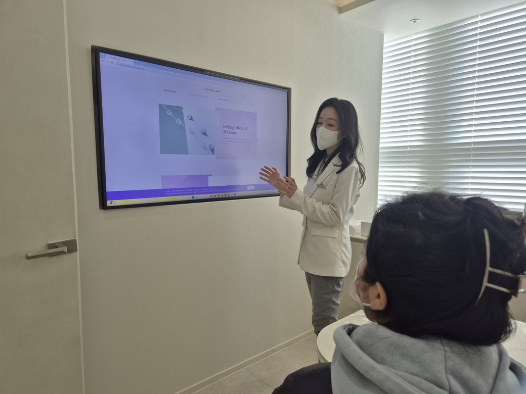 진료실 모니터 화면을 가리키며 환자에게 설명하는 최진숙 대표원장